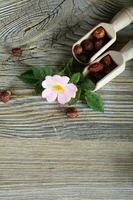 Rose hips in wooden spoons and on a wooden surface. photo