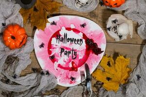 Halloween Party. Dirty red plate with silver cutlery on Halloween table. , plate photo