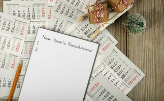 Sheet of paper with new year's resolutions on a new year's background. photo