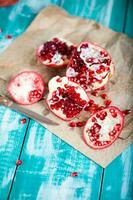 Pomegranate fruit on a cyan wooden surface. photo