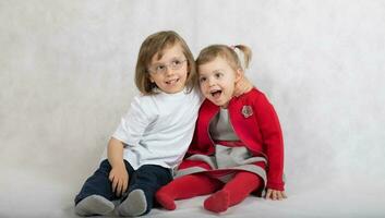 Boy of five years and girl of 2 years are sitting together. photo