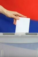 hembra mano yesos votación papel en el votación caja. foto