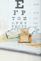 Eyeglasses for children on a eye chart close to eye pads. photo