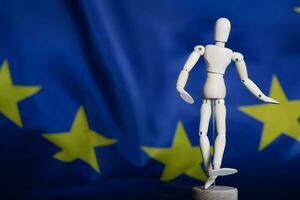 Wooden dummy figurine on European flag. photo