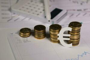 Cutout of euro sign at stacks of coins. photo