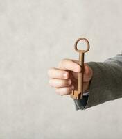 An old key in the hand of a man. Closeup photo