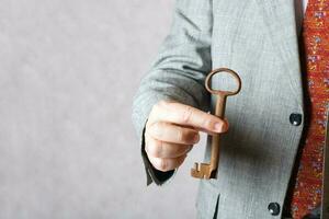 An old key in the hand of a man. photo