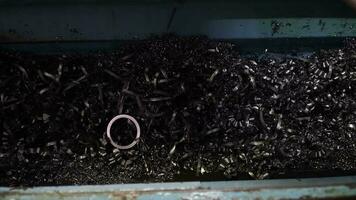 Steel Scrap Moving Scrap Conveyor Lathe Machine,Steel scrap materials recycling. Aluminum chip waste after machining metal parts on a cnc lathe. Closeup twisted spiral steel shavings. Small roughness video