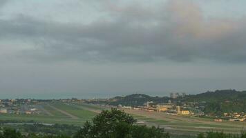 lapso de tiempo panorámico ver de el aeropuerto en tiempo de día tráfico. nubes flotador hermosamente terminado el ciudad. panorámico ver de el pista video