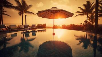 Umbrella and deck chair around outdoor swimming pool in hotel resort. photo