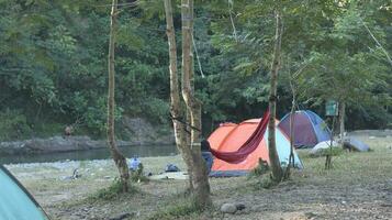 Beautiful morning landscape with camping tent on the river at sunrise photo