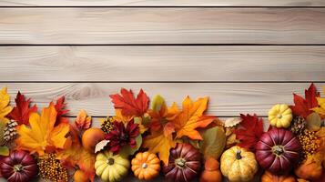 Bottom border of Autumn foliage with other fall decorations on white rustic wooden. photo