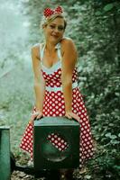 a woman in rockabilly outfit at a railroad switch photo