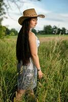 mujer con vaquero sombrero en naturaleza foto