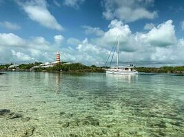 Hope Town, Elbow Cay, Bahamas May 6, 2023 A boat approaching the entrance to Hope Town Harbour at the Elbow Reef Lighthouse. photo