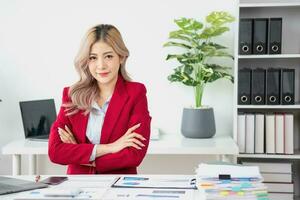 Portrait of a woman business owner showing a happy smiling face as he has successfully invested in her business using tablets and financial budget documents at work. photo