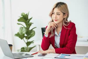 Portrait of a woman business owner showing a happy smiling face as he has successfully invested in her business using tablets and financial budget documents at work. photo