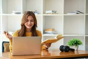 Happy latin girl college student watching distance online learning class, remote university webinar or having talk on laptop video call and use notebook to virtual meeting seminar at home or campus photo