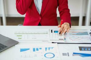 Consultant, Asian businesswoman working on the phone who discussion financial work and marketing business plan to increase company profits, ready to use computer and marketing planning documents. photo