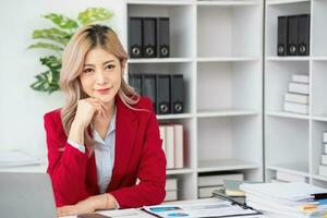 Portrait of a woman business owner showing a happy smiling face as he has successfully invested in her business using tablets and financial budget documents at work. photo
