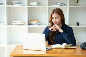 Happy young Latin female college student studying online remotely Distance university webinars Or video call on your laptop and use your computer for a virtual meeting seminar at home or on campus. photo