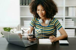 africano mujer manos utilizando computadora portátil, tableta mecanografía en teclado y surf el Internet con correo electrónico icono, correo electrónico márketing concepto, enviar correo electrónico o Boletin informativo, en línea trabajando Internet red tecnología. foto