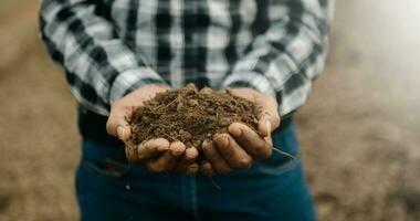 Oldman farmer holding soil in cupped hands photo