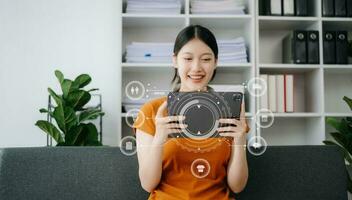 Woman using smart phone for mobile payments online shopping,omni channel,sitting on table,virtual icons graphics interface screen photo