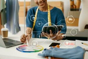 African  Woman hand using a laptop, smartphone and tablet and writing notebook at the office of her business online shopping. In home with virtual icon photo