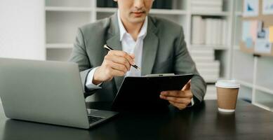 Business Asian man hand using smart phone laptop and tablet with social network diagram on desk as concept in morning light. photo