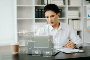 Businessman working with laptop computer and smart phone on desk in office with virtual icon diagram photo