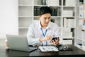 Businessman working with laptop computer and smart phone on desk in office with virtual icon diagram photo