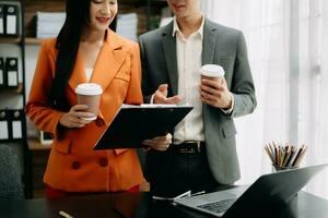 Businesswoman and team analyzing financial statement Finance task. with smart phone and laptop and  tablet. Wealth management concept photo