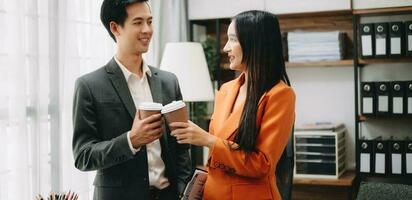 Two business worker standing and holding a coffee cup in modern office, successful, celebration, new project, team office concept photo