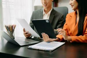 Businesswoman and team analyzing financial statement Finance task. with smart phone and laptop and  tablet. Wealth management concept photo