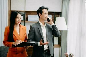 Two Asian businesswoman discuss investment project working and planning strategy with tablet laptop computer in  office. photo