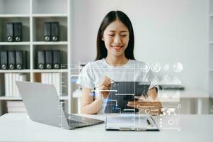 Asian Businesswoman hand Project manager working and update tasks and Gantt chart scheduling virtual diagram.with smart phone, tablet and laptop in office. photo