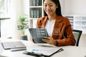 E-document management Paperless workplace, e-signing, electronic signature, document management. businesswoman signs an electronic document on a virtual notebook screen using a stylus pencil. photo