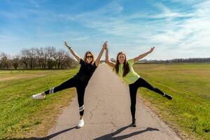 Pareja de bonito atlético mujer haciendo gimnasia ejercicios al aire libre foto