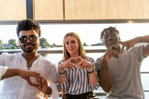 small group of young adult multiethnic friends showing heart sign with hands photo