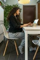 young woman is working at home on the computer during the restrictions due to the covid-19 photo