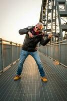 attractive middle aged musician man playing an electric violin outdoors photo