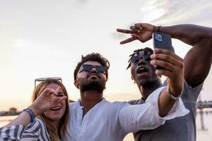 small group of multiethnic friends having fun taking a selfie with smartphone photo