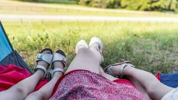 legs of mom and two young daughters without shoes coming out of the tent on the green lawn photo