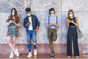 group of multiracial friends with face masks using smartphones to sharing content photo