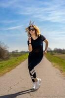 hermosa deportivo mujer teniendo divertido bailando en un país la carretera foto