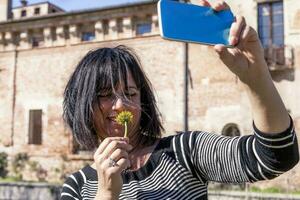 bonito mujer tomando un selfie en frente de un medieval castillo foto