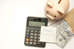 Money budget planning. Piggy bank with calculator and notebooks on white background, financial goal concept. photo