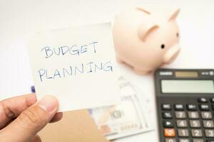 Money budget planning. Piggy bank with calculator and notebooks on white background, financial goal concept. photo