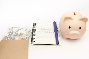 dinero presupuesto planificación. cerdito banco con calculadora y cuadernos en blanco fondo, financiero objetivo concepto. foto